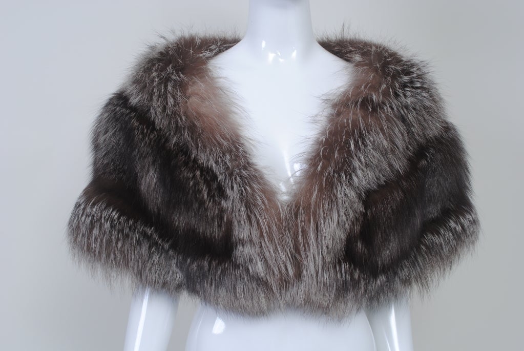 The perfect wrap for all your upcoming holiday events and beyond. Vintage silver fox stole composed of three skins graduated towards the fron, where it is clasped by a single fur hook. In very nice condition. Lined in black crepe. Also looks great