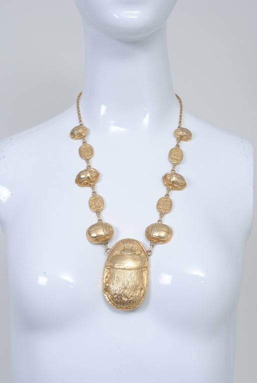 Kenneth Lane impressive scarab necklace composed of a large central scarab on chain with alternating smaller scarabs and flat hieroglyphic tablets extending on either side up to the shoulder. Scarabs are hollow cast. Oval signature plaque on inside