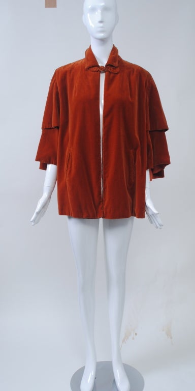 Lovely vintage piece to enhance your contemporary wardrobe. Made of cotton velvet in an unusual shade, the jacket has the look a cape, with its double-tiered wide sleeves that end below the elbow and its swing shape in back. It has a small shirt