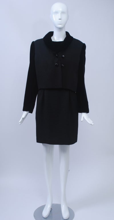 Valentino black ribbed knit dress and cropped jacket, the latter with a double row of buttons, a ribbed body with contrasting velvet sleeves and single lapel. Underneath is a sleeveless dress with velvet bodice and short ribbed skirt. Shoulder pads