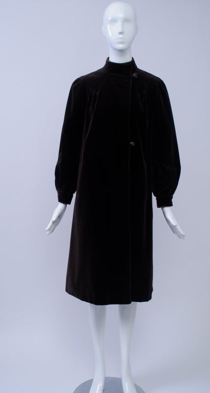 Brown velvet coat with nice yoke detailing running from V in back around shoulders and containing gentle shirring for full sleeves and back. Mandarin collar and off-center closure consisting of two buttons with loops and an interior button at neck.