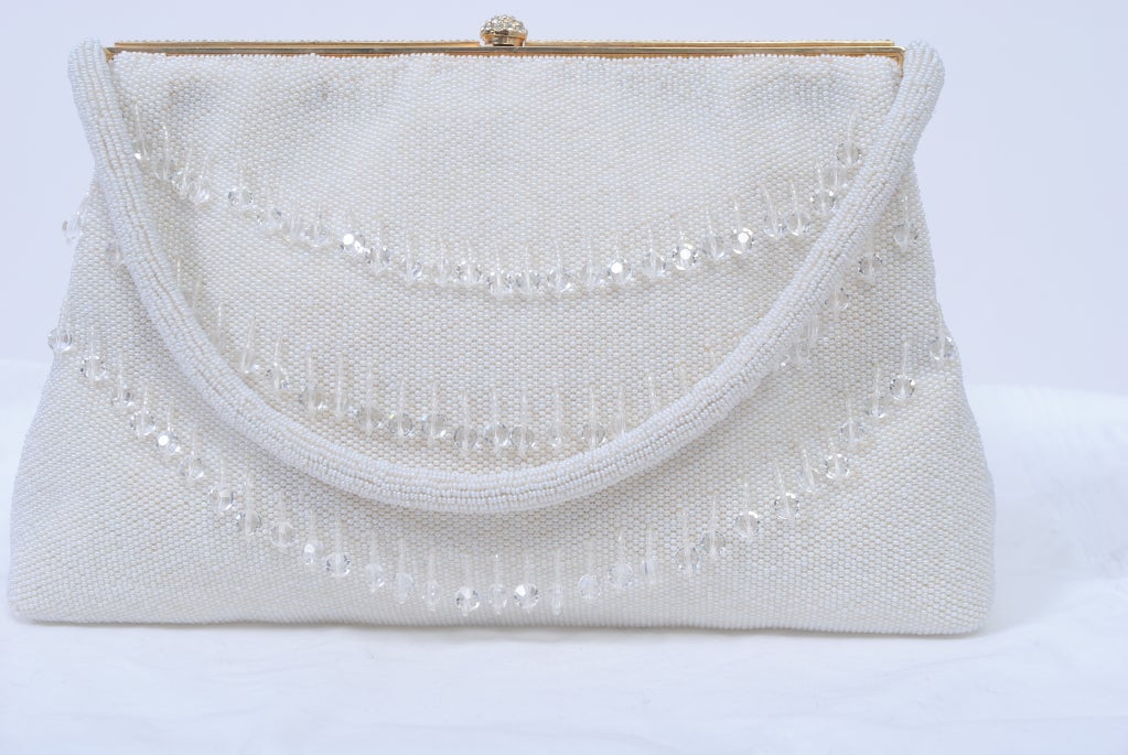 Microbeaded of tiny pearl seed beads, this evening bag is further embellished front and back with three curved rows of dangling crystals. perfect for a wedding and/or summer events.  The gold metal frame has a string is imbedded with a row of