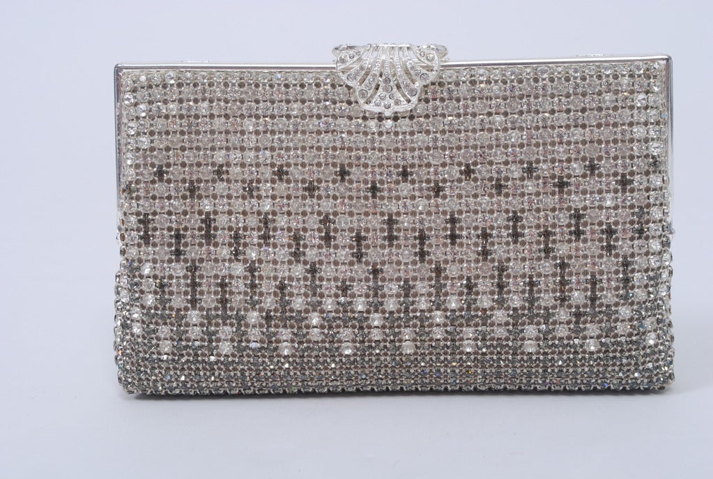 Beautiful evening bag studded all over with clear and charcoal rhinestones in a geometric pattern can be worn as a clutch or with its silver chain. Rhinestone clasp and white satin lining with side pocket. Small pink marks on lining, otherwise in