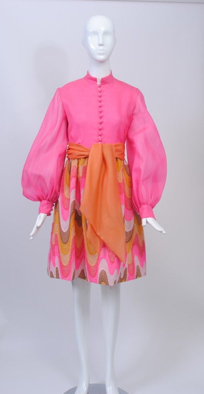 Not your typical Bill Blass dress, this dress reflects the youthful aesthetic of its period. Designed c.1970, which is the first year Blass manufactured under his eponymous label, the dress features a hot pink organza bodice and a complementary