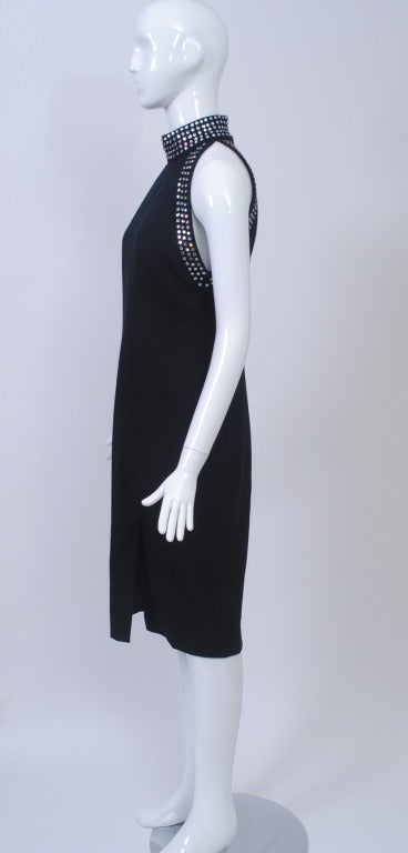 Dieses Kleid von Tom und Linda Platt aus den 1980er Jahren schmeichelt der Figur mit seiner kurvenreichen Silhouette und den eingeschnittenen Armlöchern. Aus schwarzem Woll-Crêpe mit hohem Ausschnitt und Ärmelbündchen:: die mit Reihen von klaren