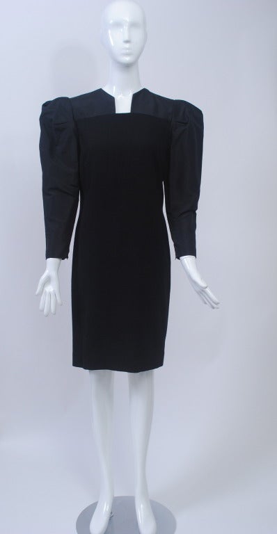 Pauline Trigère was known for her architectural designs, as exhibited here in a LBD from the latter part of her career. The narrow simple shape of the body in black wool crepe contrasts with the volume and fabric at the shoulders and yoke, which is