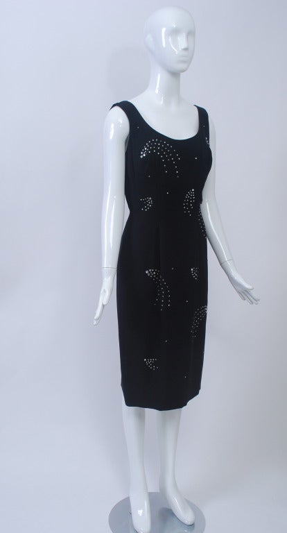 1960s black crepe sheath from Lilli Diamond, one of California's foremost manufacturers during the mid-twentieth century. The simple tank shape hugs the body and is embellished with sprays of rhinestone starbursts, small and large, throughout. Low