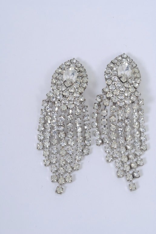 Large vintage rhinestone earrings, each earclip set with a large marquise surrounded by two conforming rows of smaller round stones, which are the same size as the graduated strings that hang down from the earclip.