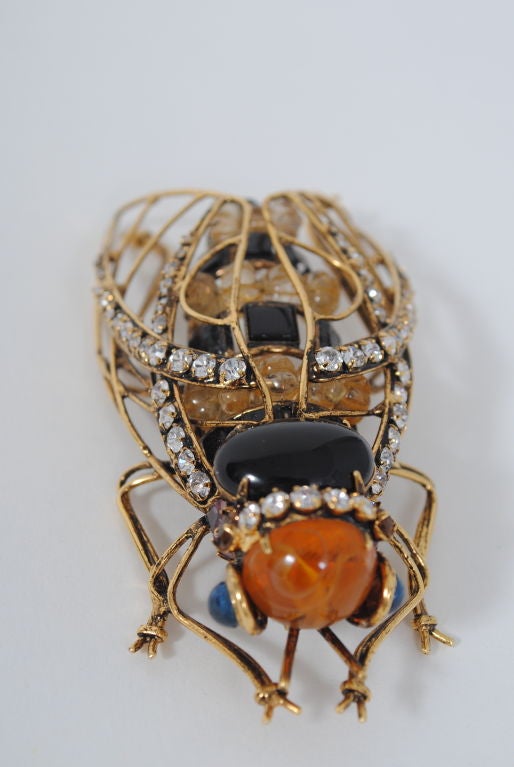 This large, dramatic bug brooch by Iradj Moini, known for his extravagant, large-scale jewelry comprised of natural gemstones on a brass frame, will certainly make a statement perched on your favorite coat or jacket. Moini, who designed for Oscar de