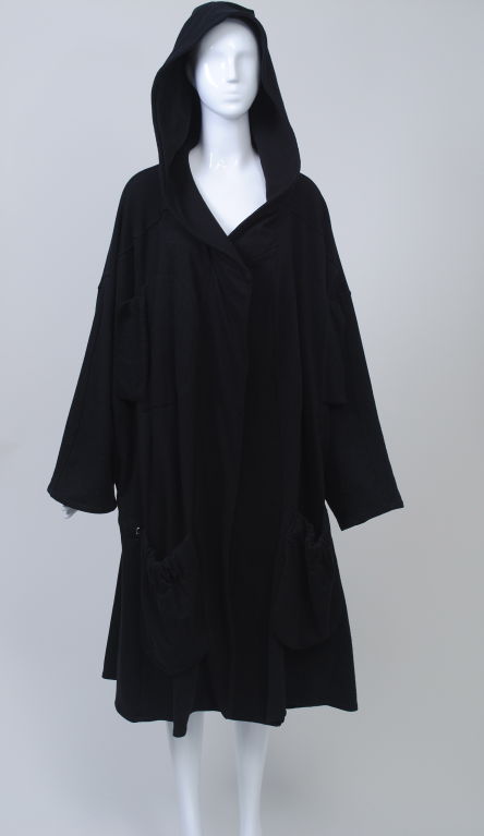 A rare find, this Body Map coat is an iconic example of the work of this forward-looking British brand that flourished during the 1980s.  The oversized proportion envelops the body from the hood to its mid-calf length, and is cleverly pulled in