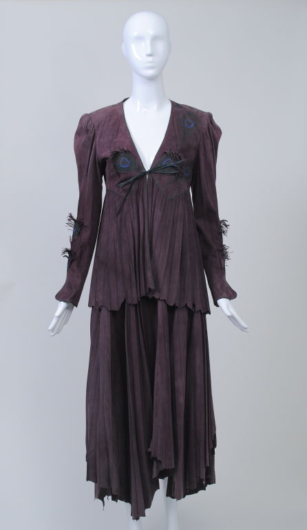 Fabulous! Roberto Cavalli suede jacket and skirt in the most beautiful shade of soft plum, embellished with stamped and appliquéd peacock motifs with fringe. Knife pleated skirt and lower part of jacket, both with raw, uneven, handkerchief hem.