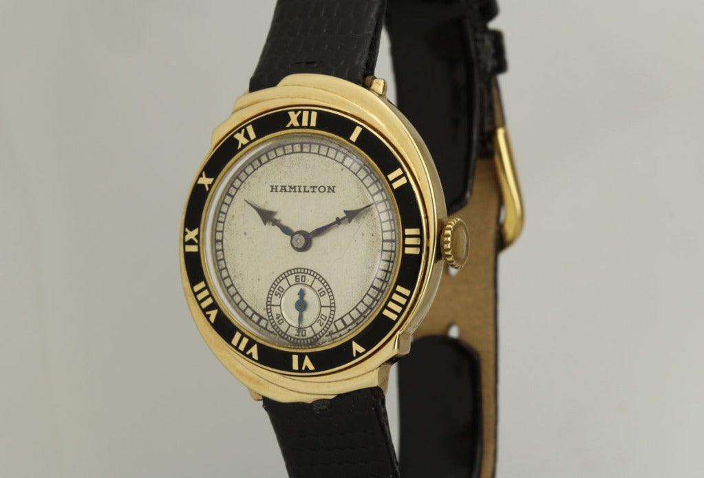 This is a very rare and desirable Hamilton in 14k yellow gold wristwatch named the Spur. The sculptured spiral case features a black enamel bezel with Roman numerals. The original silvered dial has some aging as do the elegant Cathedral-style hands.