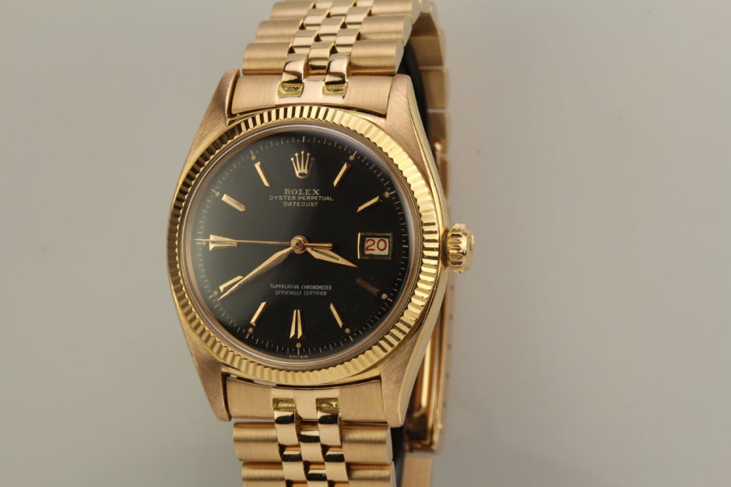 This is an exceptional example of a rare variation of an early Rolex Datejust wristwatch in 18k rose gold from the 1950s. It is a reference 6605. The original black dial, which is extremely rare, is in excellent condition. The case is mint and the