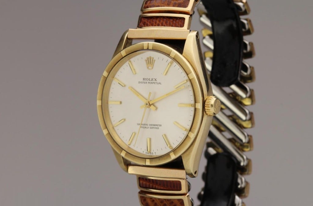 Rolex 14k yellow gold Oyster Perpetual wristwatch, Ref. 1007, with an engine-turned bezel, a silvered dial, automatic movement, on a very unusual period Champion stretch bracelet.