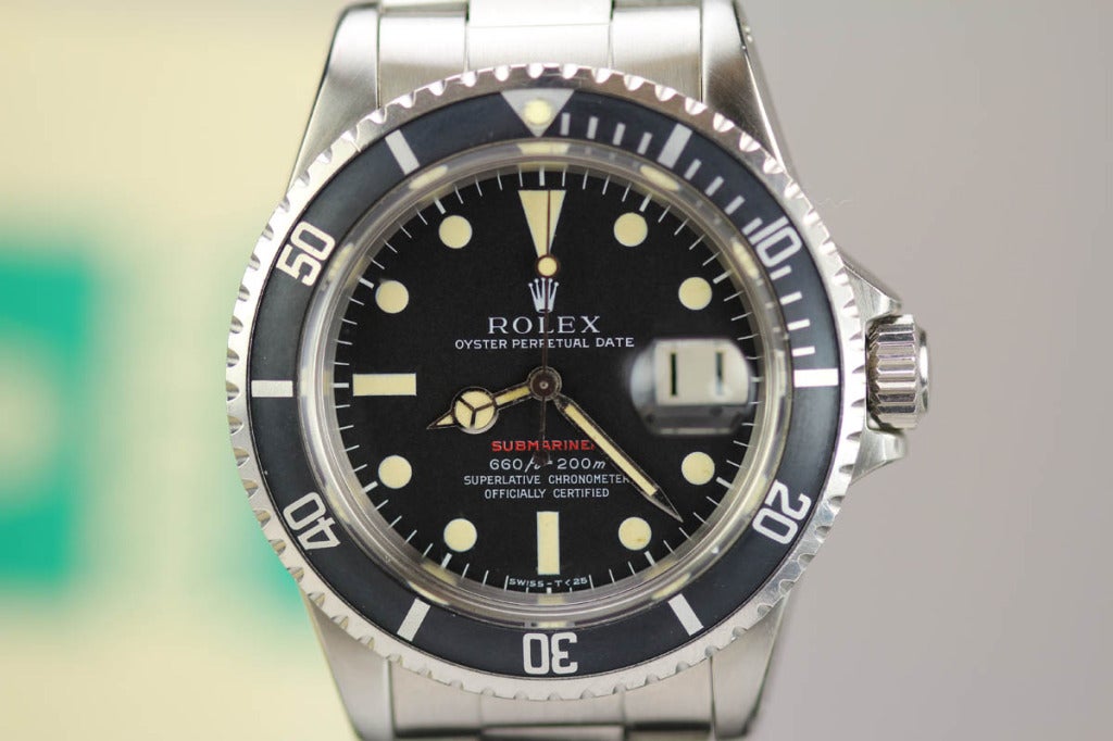 This is an early example of a Rolex Submariner Date reference 1680 with submariner written in red. The case is in beautiful condition, comes on an original flip lock bracelet, box, hang tags, anchor, punch papers, and booklets.