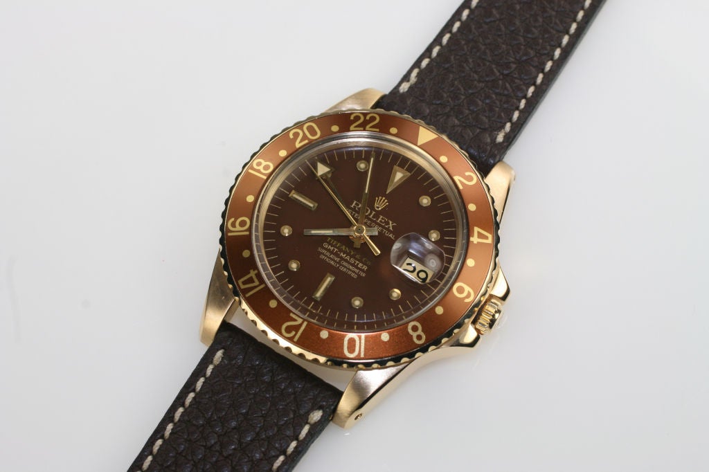 Rolex 18k Oyster Perpetual GMT-Master Retailed for Tiffany & Co. reference 1675. This watch has an automatic movement, a screw down back, brown dial, date at the 3 o'clock, plastic crystal, brown/gold 24-hour bezel,on a brown leather strap. Circa