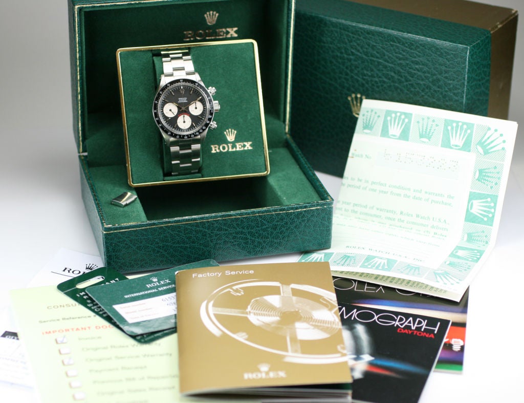 This is a great example of the Rolex Daytona reference 6263 with the original box, guarantee, and bill of sale. This watch has the most desirable combination of the acrylic bezel and black dial with big red daytona. The case dial and movement are