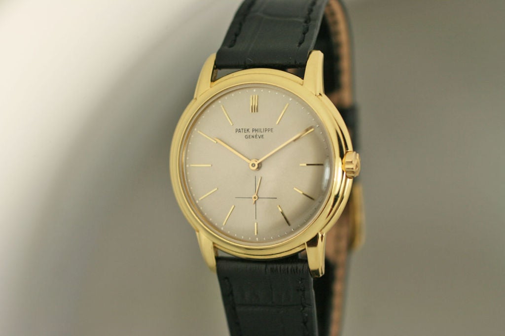 This watch is 1961 Patek Philippe 18k yellow gold Disco Volante reference 2551. The 35mm case has a stepped bezel and slim dress watch design perfect for wearing under dress shirts. It has a silvered dial with gold line indexes and needle shaped