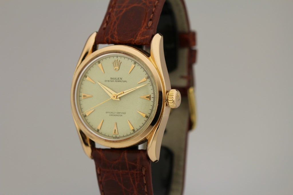 This is a 18k rose gold Rolex Oyster Perpetual wristwatch, Officially Certified Chronometer, known as the BombÃ?©, from the 1950s. The case has beautiful lines due to the twisted faceted lugs, thicker looking case, and high domed crystal. The dial