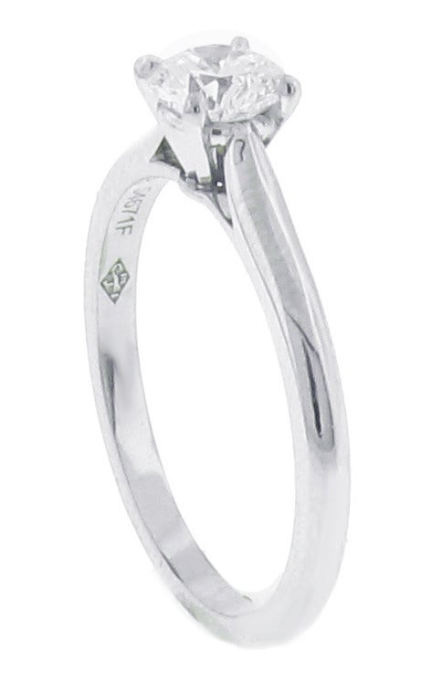 This beautiful Cartier diamond solitaire ring features a beautiful .65 carat round diamond in a four prong platinum setting. The diamond is has a color grade of 