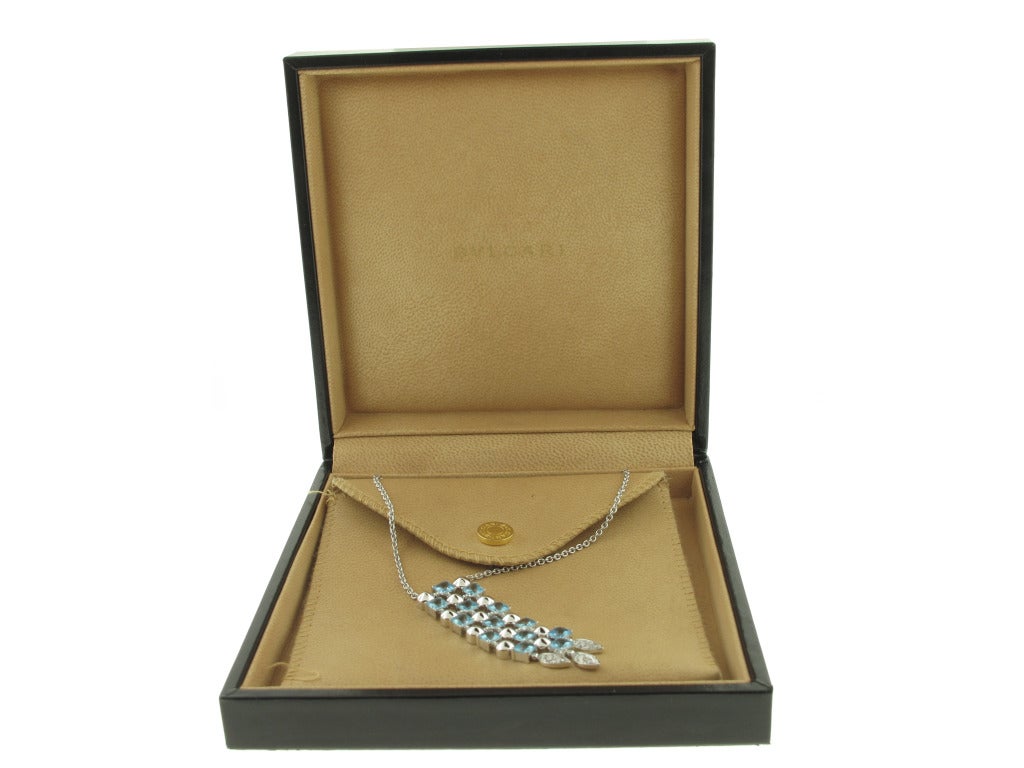 This Bulgari Lucia necklace features a stunning 2.5 inch long drop pendant that hangs from an adjustable 18 inch chain. The pendant features blue topaz and .27 carats of diamonds. The necklace is 18 karat white gold. The necklace is as new and comes