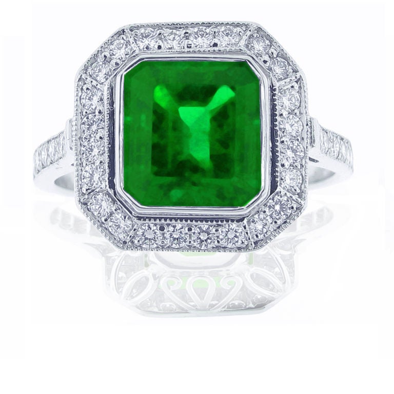 Platinum, emerald and diamond ring. This ring features a 2.08 carat center colombian emerald surrounded by 36 micro-pavé diamonds that have a total weight of .50 carats.  Hand-carved delicate scroll-work adorns this exquisite ring that is a custom