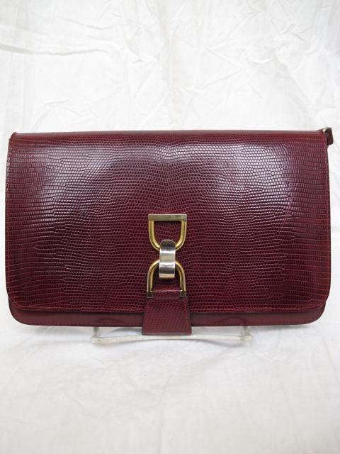 Here is this 100% authentic Gucci bag.<br />
<br />
* It's made of burgundy lizard snake skin with a pinch hardware closure.<br />
* It has a detachable matching shoulder strap.<br />
* It has an open slip pocket on the back.<br />
* The