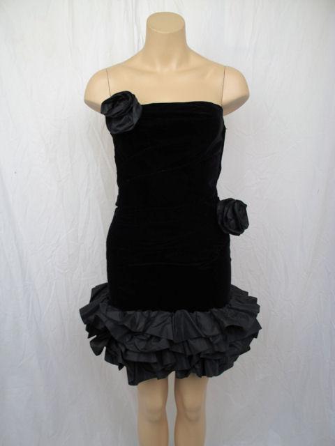 This sexy cocktail dress is perfect for a night out on the town.

* It has light ruching on the right side of the waist with a ruffled taffeta hemline & two attached flowers.
* It's fully lined & closes with a zipper down the side.
* It's in