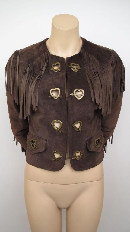 Here is this 100% auth Moschino fringed cropped jacket.

* It's made of brown suede with bronze tone heart & arrow closures.
* It has two flap pockets & fringe detailing throughout.
* It's in excellent condition with no stains or damage.
* It's
