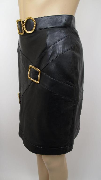 Here is a luxurious 1980s Chanel pencil skirt.

* It's made of luxurious black lambskin leather & has gilt hardware.
* It's fully lined & closes with a zipper & logo button in the back.

Skirt
Waist: 26