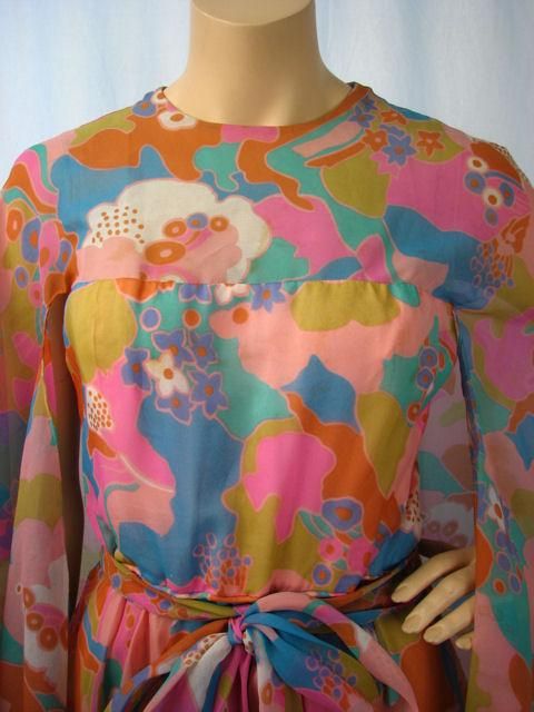* Gorgeous 1960's pastel floral gown designed by Elinor Simmons for Malcolm Starr. <br />
* The best part of this dress is the cool attached cape-like, bat-wing sleeves.<br />
* Floral print in shades of pinks, blues & rust.  <br />
* It has a