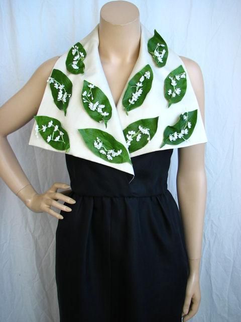 * This stunning dress has the cutest white flowers on green leaves on the over-sized ivory lapels.<br />
* It's unlined & closes with a black metal zipper on the side.<br />
<br />
Measurements:<br />
<br />
Chest 34<br />
Waist 26<br />
Hips