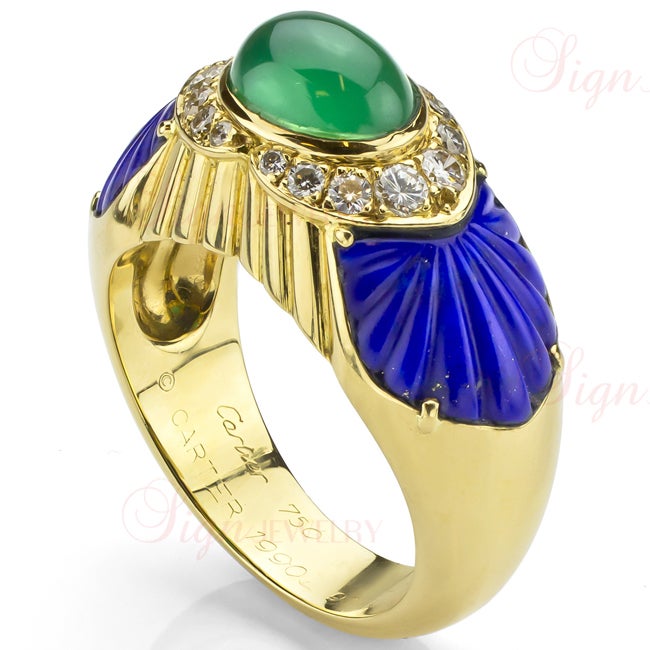 Exotic and alluring, this authentic Cartier ring was made in 1990 from 18k yellow gold and features a stunning oval green rohodochrosite crown encircled by natural round diamonds and flanked by beautifully carved blue lapis fans.
GRAM WEIGHT: