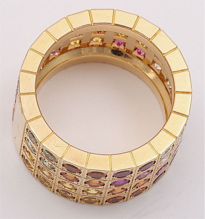 This stunning Cartier ring is made from 18k yellow gold and features natural multicolor (orange, pink, fuchsia) sapphires and diamonds. French size 52. US size 6-6.25