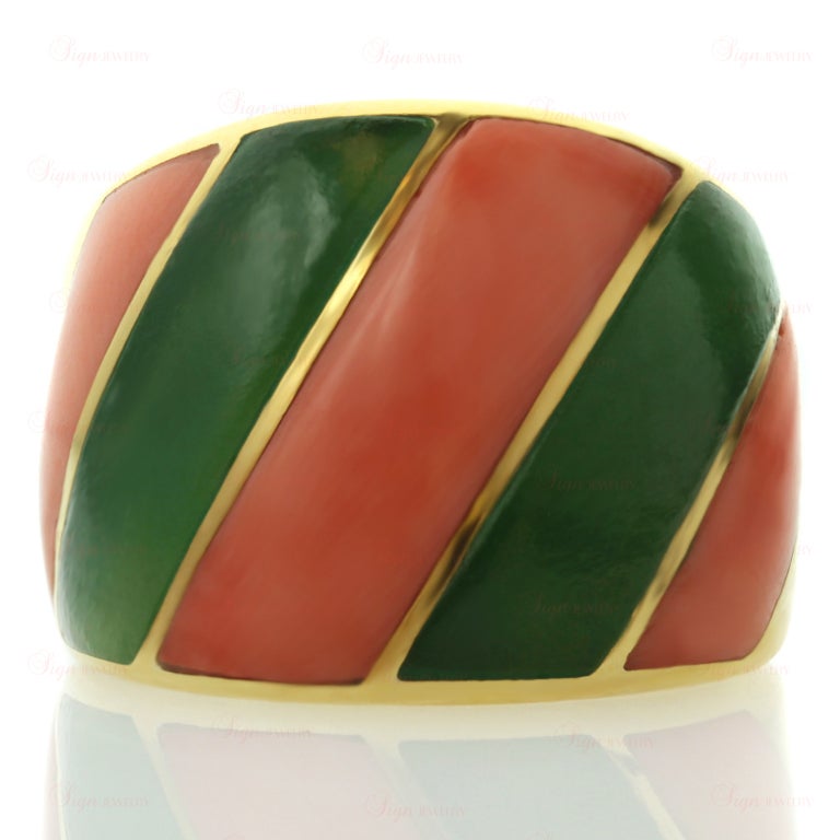 This rare Cartier band is made in 18k yellow gold and beautifully inlaid with diagonal stripes of rose coral and green jadeite. Circa 1960s. A chic and festive design.
5mm - 16mm Width.
Ring Size 6.5 - EU 53.
Total Gram Weight: 11.2.