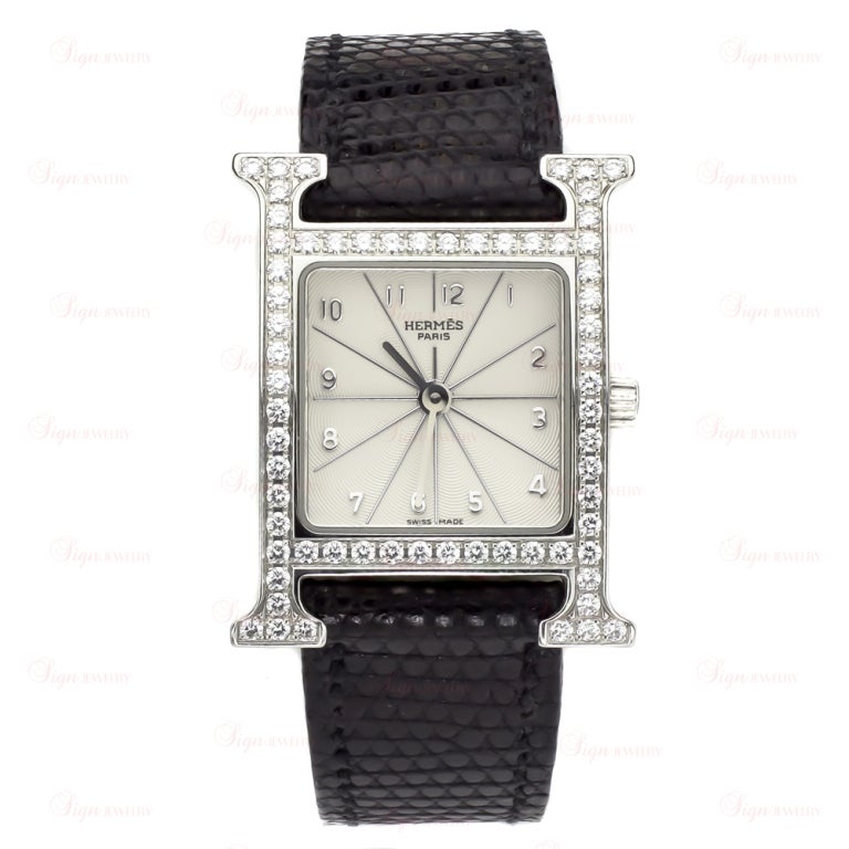 A classic Hermes wristwatch featuring a sparkling stainless steel case pave-set with 64 natural diamonds weighing an estimated 1.08 carats, a textured silvered white dial and stainless steel numbers and markers. The band is made from authentic