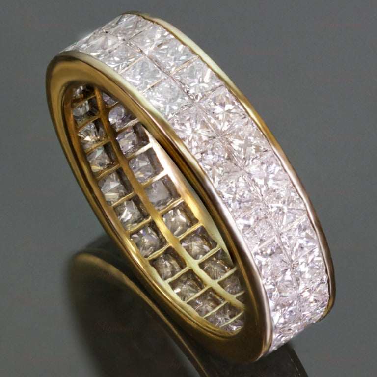 This elegant eternity band is made in 18k yellow gold and features an invisible channel setting of sparkling princess-cut G-H VS1-VS2 diamonds of an estimated 4.0 carats. A timeless design. Ring Size is 6.5 - EU 53. Non-resizable.