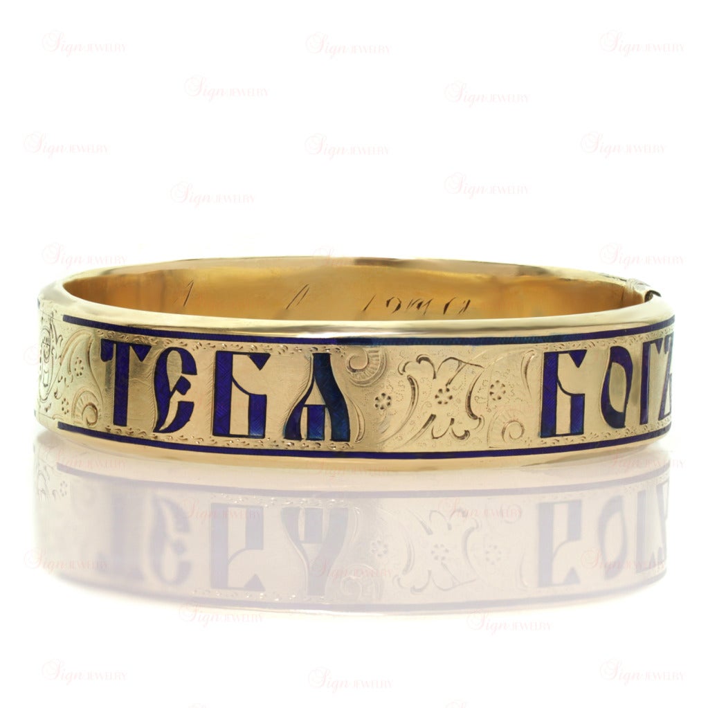 This rare and original oval bangle bracelet is made in 14k white gold and features a beautiful blue enamel inscription in old Cyrillic letters. The phrase is in Russian and reads 