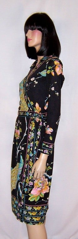 Offered for sale is this striking and versatile black wrap dress with colorful peacock and floral design patterns. The dress has two interior ties for closure and two exterior ties for additional closure. The dress is comfortable and can easily be