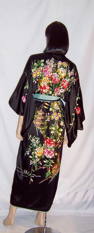 This is an exquisite and elaborately embroidered black Japanese kimono with its own sash lined in  pale turquoise silk. There is a minimal amount of embroidery on the front of the kimono, but the back is almost entirely covered with embroidery, in