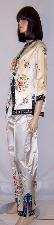 This is a lovely and luxurious, 1940's vintage, white silk Chinese hand-embroidered jacket and pants ensemble.  The jacket has six floral roundels embellishing it interspersed with florals in between.  It has been fitted with a metal zipper for