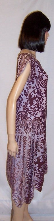 This is a wonderful 1920's vintage, mauve voided velvet dress with scalloped short sleeves and a scalloped hem line. The dress must be slipped over one's head to be worn and had been designed to fall straight from the shoulders. There is a small