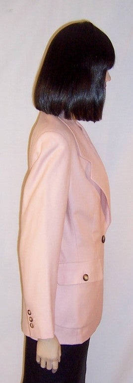 Offered for sale is this luscious pink woolen, single-breasted blazer masterfully tailored and detailed by Michael Kors.  The blazer has an one button closure at the waist line, a buttoned pocket at each hip, and three decorative buttons at each