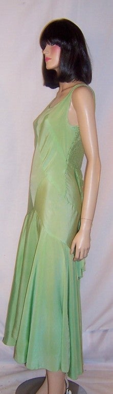 This is a gorgeous, 1930's vintage, bias-cut, pastel green silk crepe gown with couture construction and design elements.  The gown is sleeveless with a scoop neck in the front as well as the back.  The silk crepe bodice in the front has