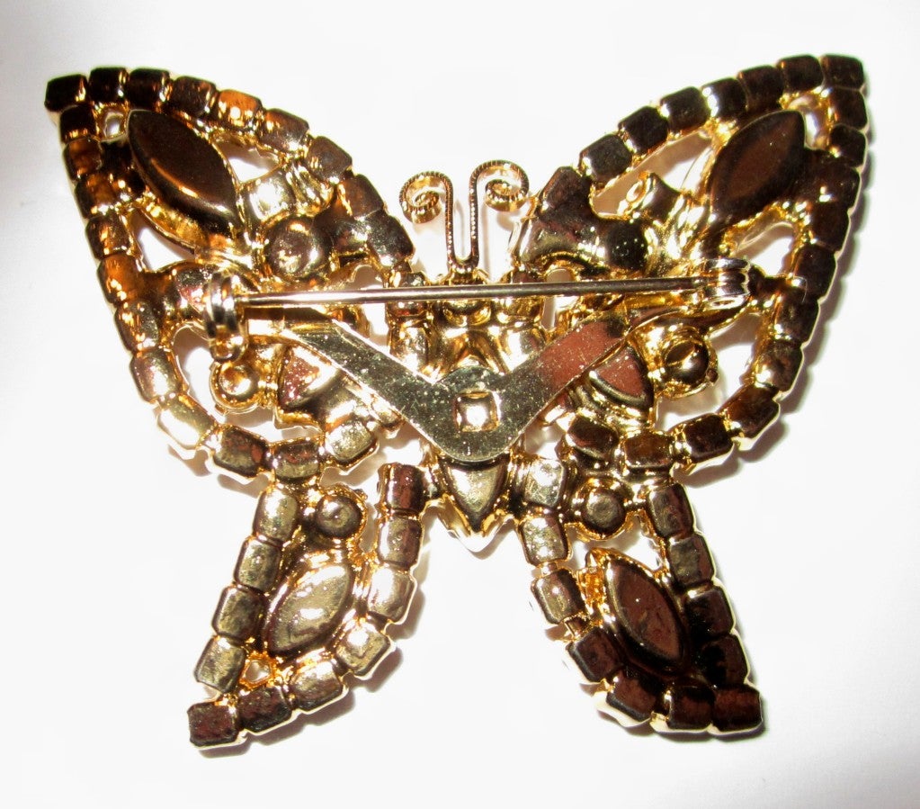 This is a lovely, 1960's vintage, amber-colored, pronged set, butterfly brooch comprised of rounded and marquis-shaped rhinestones in varying sizes and shapes. The brooch measures 2.25