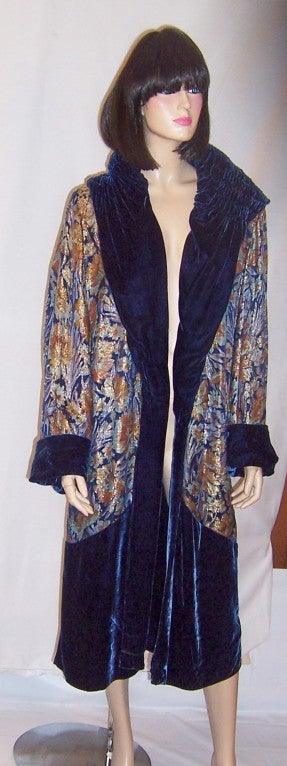Offered for sale is this superb and opulent 1920's vintage, Prussian blue silk velvet and floral printed lame opera/evening coat which is reversible and is in excellent vintage condition.  The colors of the lame are bright and vibrant in hues of