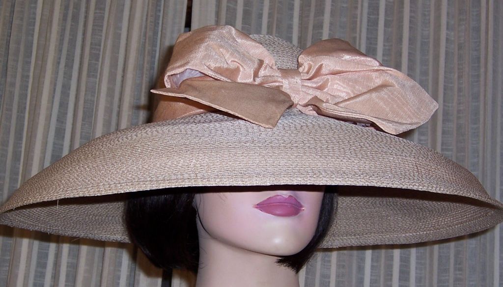 This is a fabulous, 1980's vintage, Eric Javits tan straw, wide brimmed hat with an ample full bow, front and center. The brim spans 6