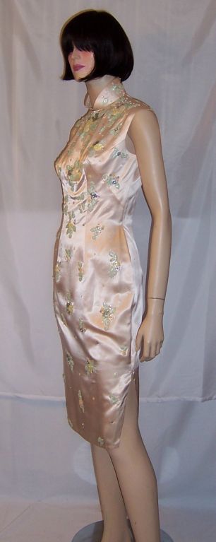 This is a very beautiful and slinky 1950's pale pink silk cheongsam with a mandarin collar, fitted waist and hips, slits up either sides of the skirt, and a side zipper on the right side for closure. There are also snaps up the right side of the