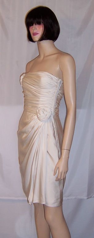 This is a strikingly simple and elegant white silk cocktail dress and matching stole/wrap designed by Lanvin and of the 1980's vintage. The dress has a side zipper for closure and two large silk flowers, one at the top of the bodice and the other at