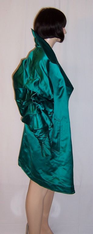 This is a striking broad-shouldered coat designed by Claude Montana in viridian green silk. Montana was a forceful and influential designer with an international reputation. His designs always made a fashion statement through his mix of details and
